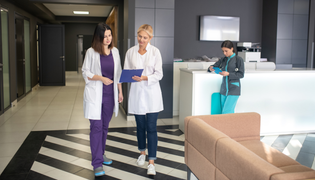 This is a photo of two female doctors looking at a clipboard.