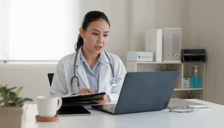A doctor sitting at her desk looking at a computer