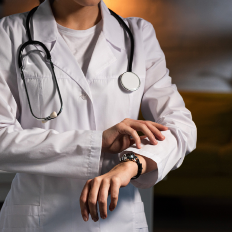 This is a picture of a doctor checking the time on their watch.