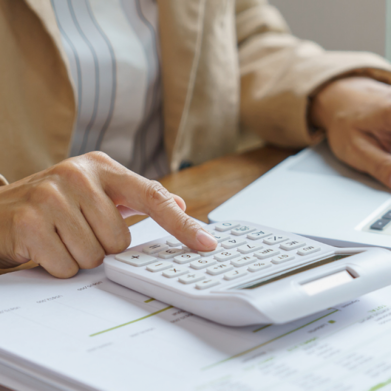 A person typing on a calculator