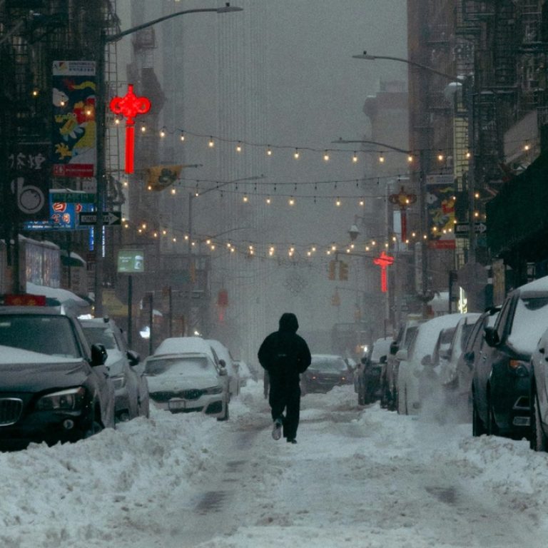 A person walking through a snowy city.
